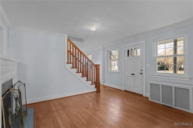 entrance foyer with radiator, crown molding, and wood-type flooring