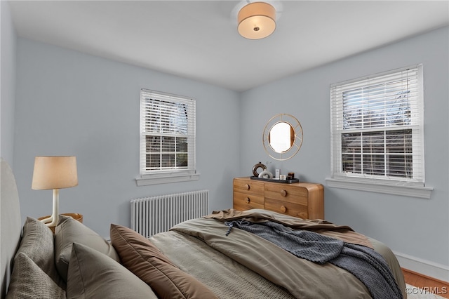 bedroom with hardwood / wood-style flooring and radiator