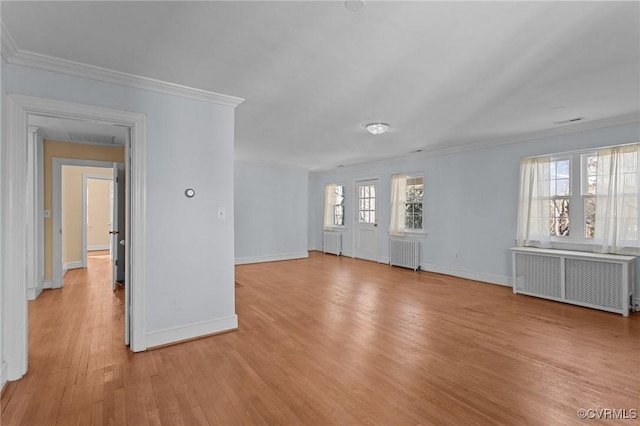 empty room with radiator heating unit, light hardwood / wood-style flooring, and crown molding