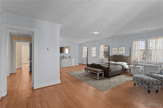 bedroom featuring multiple windows, crown molding, and light hardwood / wood-style flooring