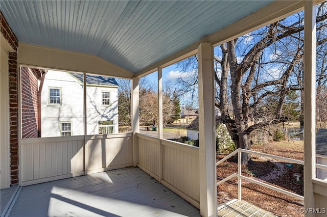 unfurnished sunroom featuring vaulted ceiling