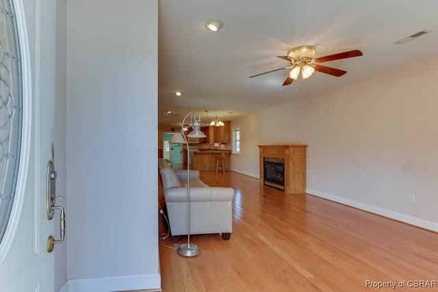 living room featuring light wood-type flooring and ceiling fan