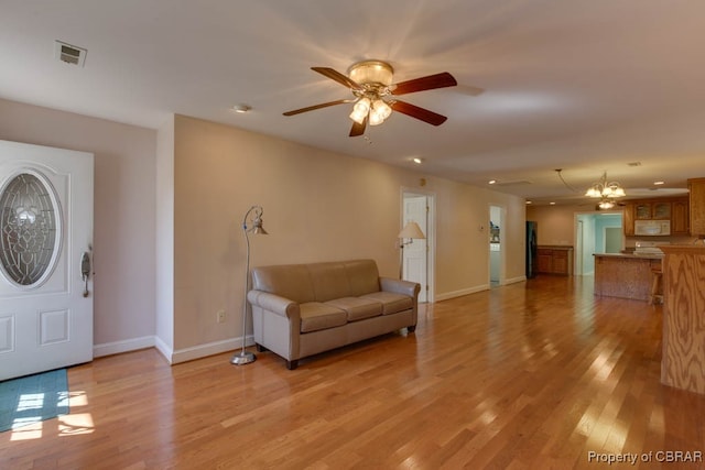 interior space featuring light hardwood / wood-style flooring and ceiling fan with notable chandelier