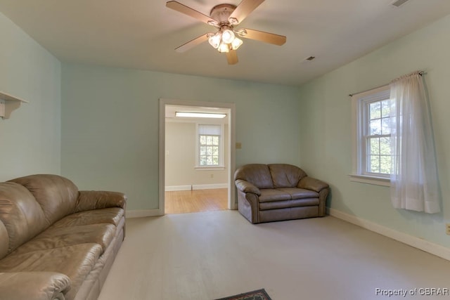 living room with light wood-type flooring, plenty of natural light, and ceiling fan