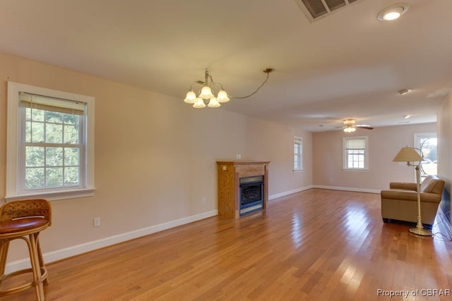 living room with hardwood / wood-style flooring and ceiling fan with notable chandelier