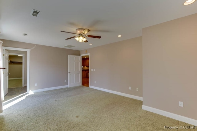 carpeted spare room featuring ceiling fan