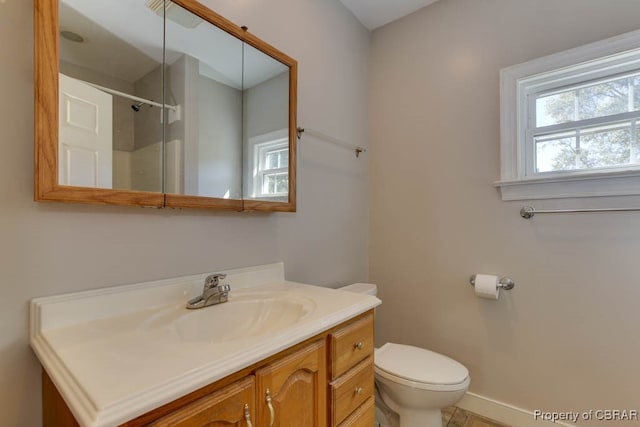 bathroom with vanity, toilet, and a shower