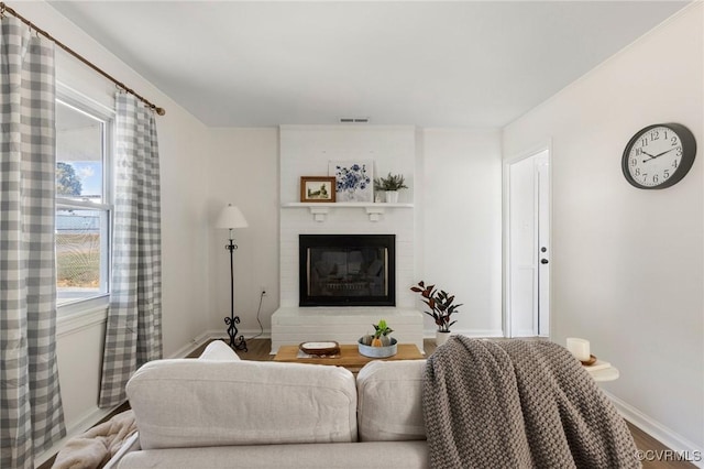 living room with a large fireplace, hardwood / wood-style floors, and plenty of natural light