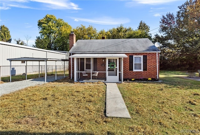 view of front of property with a sunroom, a front yard, and a carport