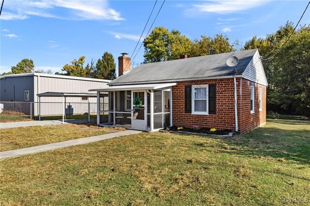 view of front of property featuring a sunroom and a front yard