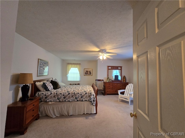 bedroom featuring light carpet, a textured ceiling, and ceiling fan