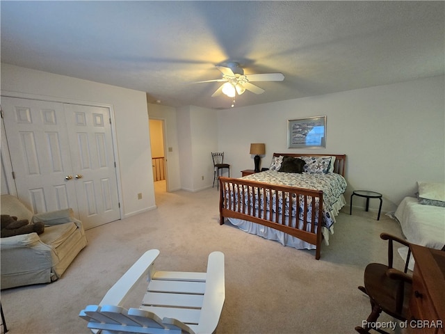 carpeted bedroom featuring a closet, a textured ceiling, and ceiling fan