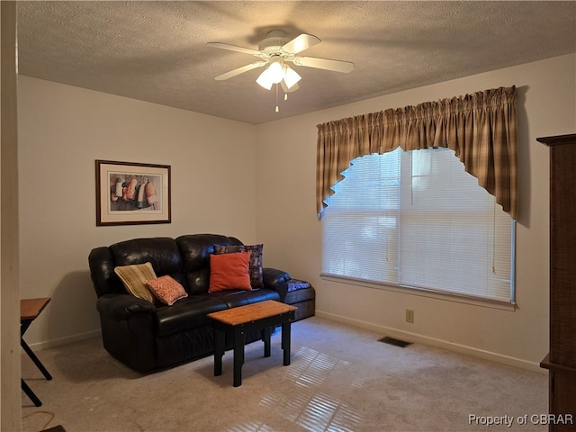 sitting room featuring light carpet, a textured ceiling, and ceiling fan