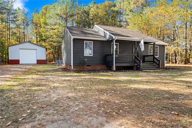 view of front of home featuring covered porch, a garage, and an outbuilding