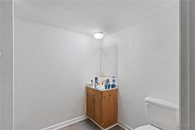 bathroom featuring vanity, hardwood / wood-style flooring, and toilet