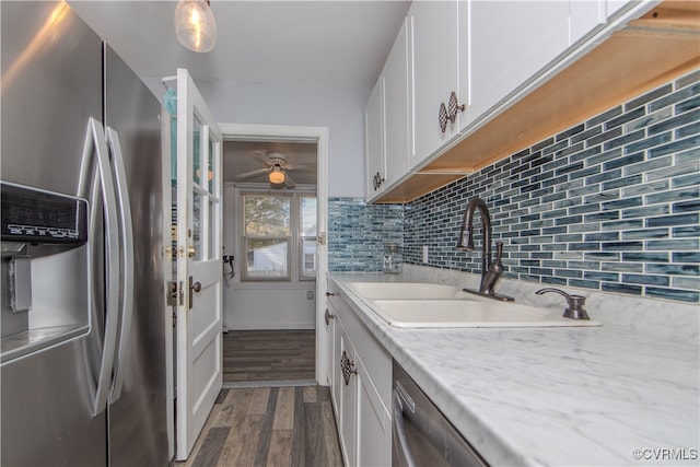 kitchen featuring stainless steel appliances, white cabinetry, sink, and light stone counters