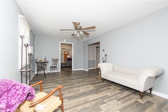 living room featuring ceiling fan and dark hardwood / wood-style floors