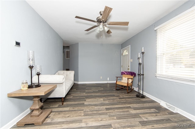 living area featuring dark hardwood / wood-style floors and ceiling fan