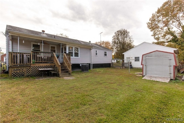 back of property featuring cooling unit, a yard, a wooden deck, and a shed