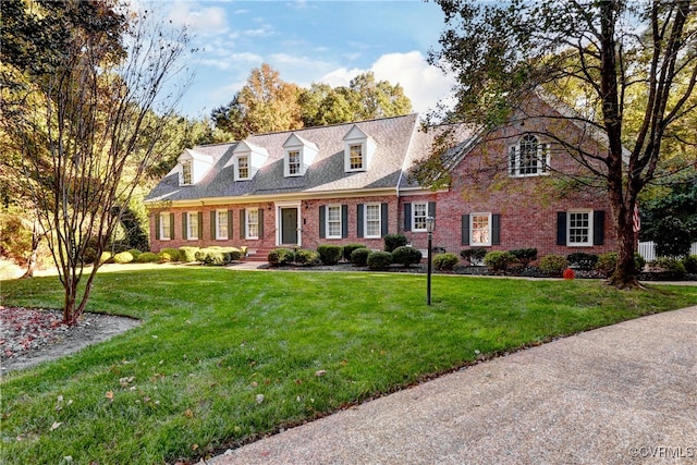 new england style home featuring a front lawn