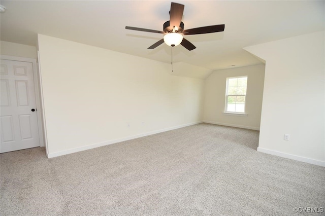 spare room featuring vaulted ceiling, light carpet, and ceiling fan