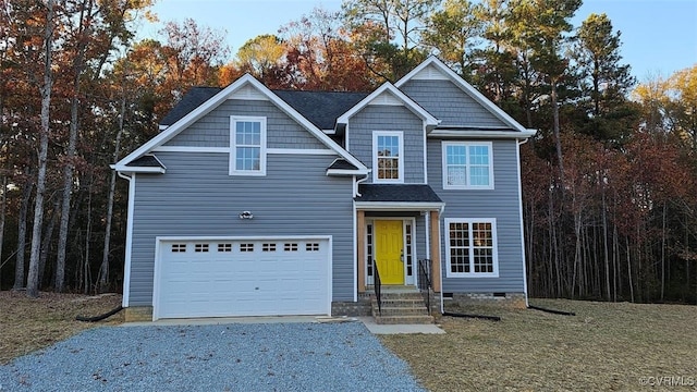 view of front of property featuring an attached garage and gravel driveway