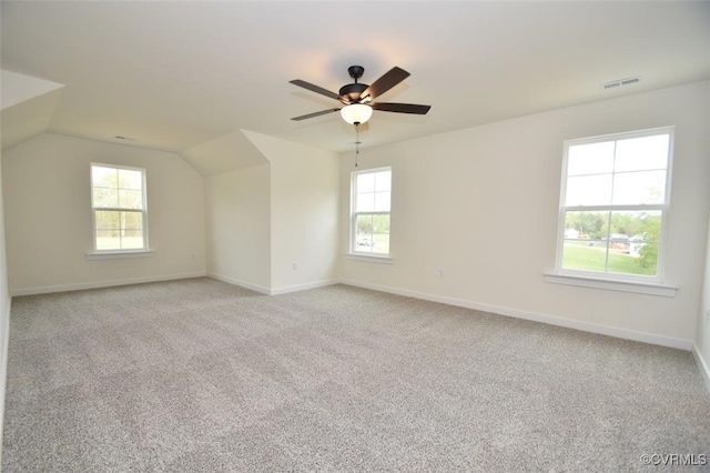 unfurnished room with light carpet, baseboards, visible vents, ceiling fan, and vaulted ceiling