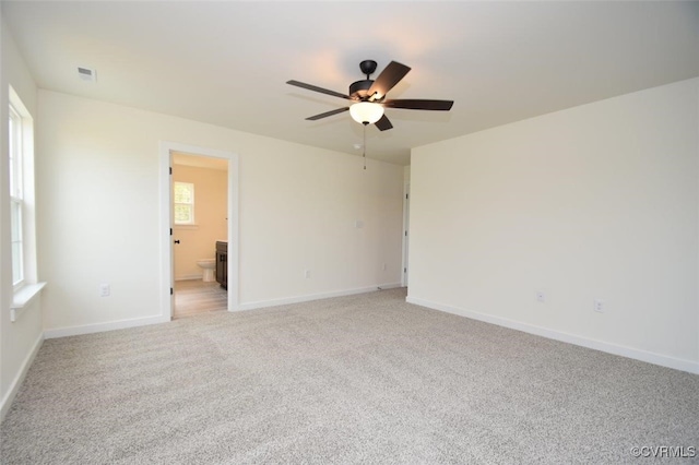 unfurnished room with light colored carpet, ceiling fan, visible vents, and baseboards