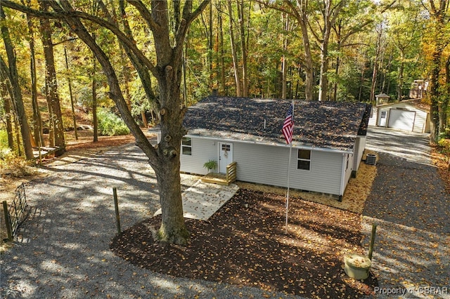 view of side of property featuring central AC, an outdoor structure, and a garage