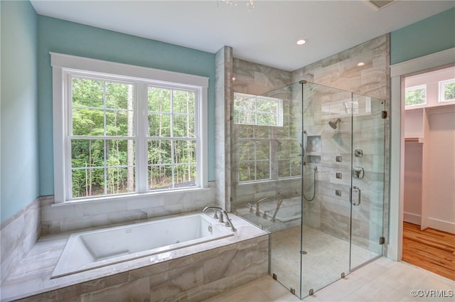 bathroom featuring shower with separate bathtub, wood-type flooring, and plenty of natural light