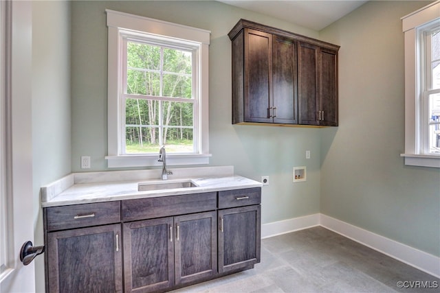 clothes washing area featuring sink, washer hookup, hookup for an electric dryer, and cabinets