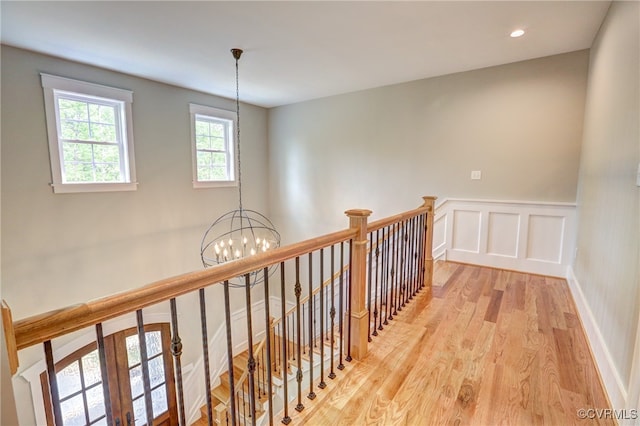 hallway featuring light hardwood / wood-style floors and an inviting chandelier