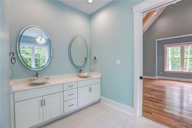 bathroom with vanity, hardwood / wood-style floors, and lofted ceiling