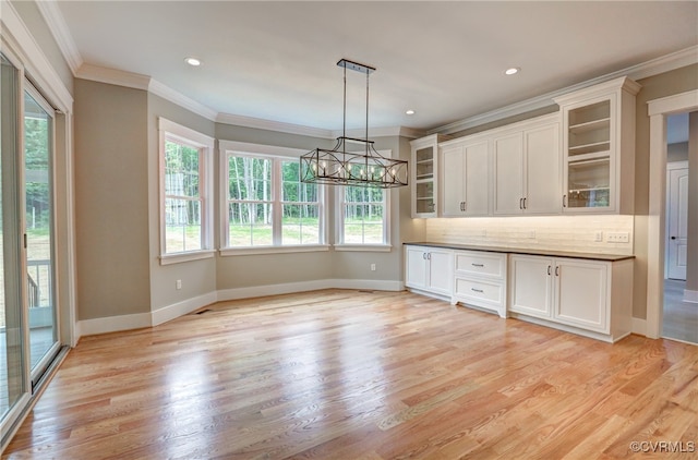 kitchen with backsplash, a chandelier, hanging light fixtures, and light hardwood / wood-style floors