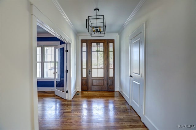 foyer featuring ornamental molding, a chandelier, and dark hardwood / wood-style floors