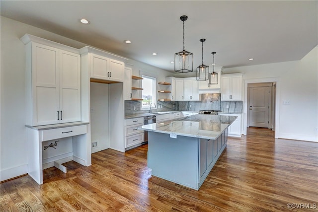 kitchen featuring light hardwood / wood-style floors, a center island, pendant lighting, and white cabinets