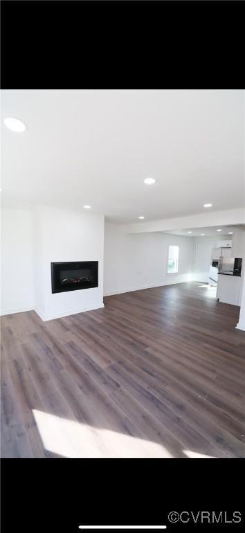 unfurnished living room with dark wood-type flooring