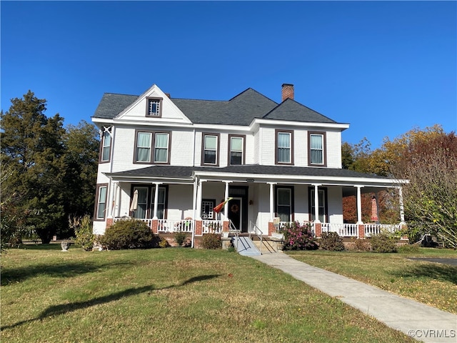 view of front facade featuring a chimney, covered porch, and a front lawn