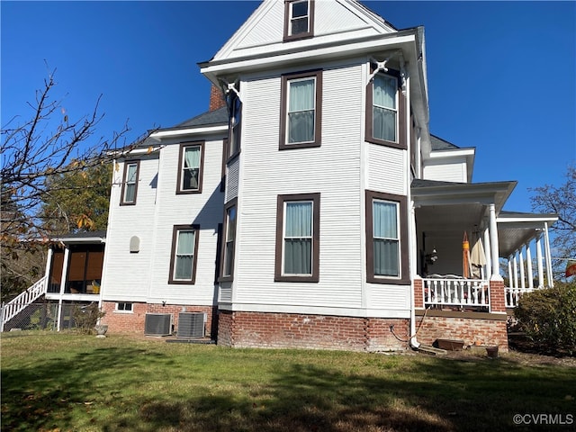 exterior space with a lawn, covered porch, and central AC unit