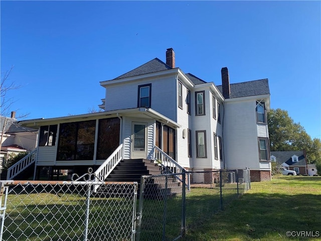 view of front of home featuring a sunroom, a chimney, fence, a front lawn, and a gate