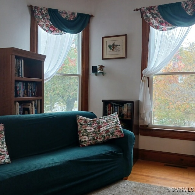 sitting room with visible vents, baseboards, and wood finished floors