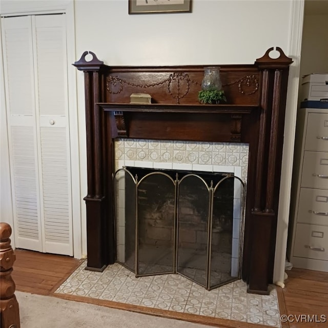 interior details featuring a tile fireplace and hardwood / wood-style flooring