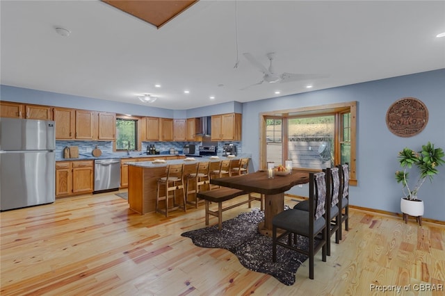 dining area with sink, light hardwood / wood-style flooring, and ceiling fan