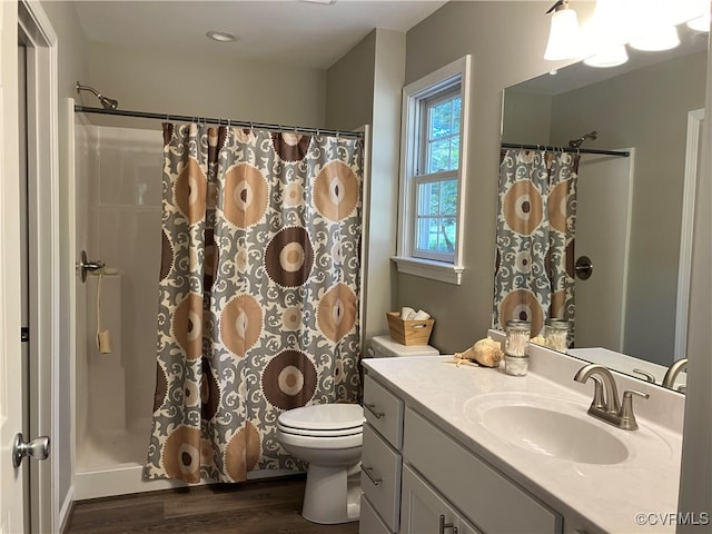 bathroom with vanity, hardwood / wood-style floors, toilet, and walk in shower