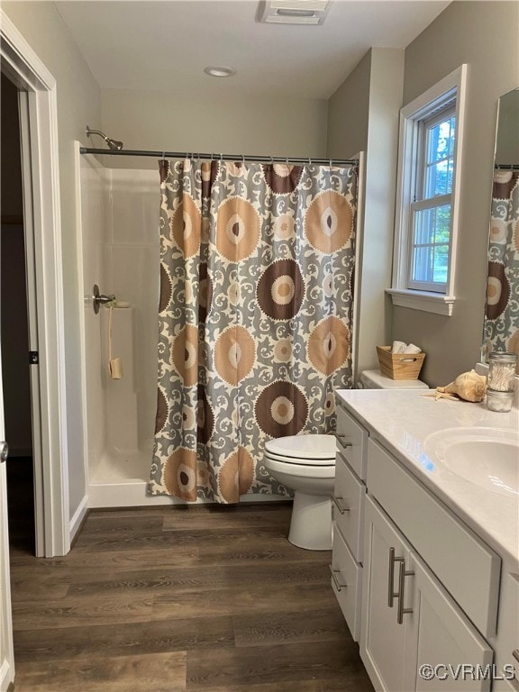 bathroom featuring vanity, hardwood / wood-style floors, a shower with shower curtain, and toilet