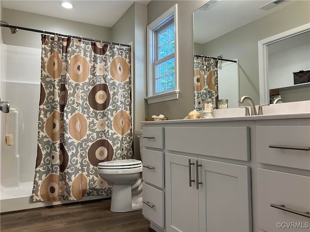 bathroom featuring vanity, wood-type flooring, toilet, and walk in shower