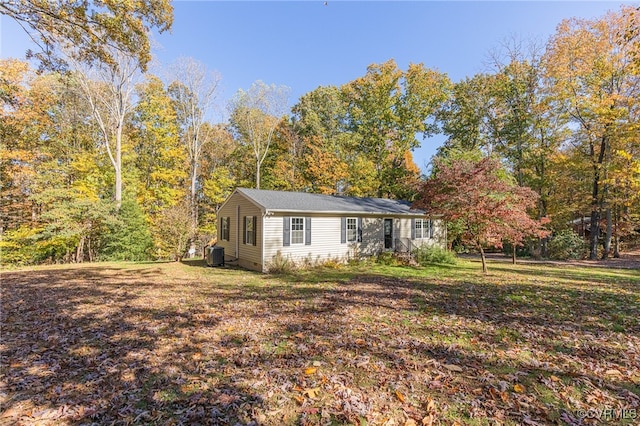 ranch-style home with central air condition unit and a front lawn