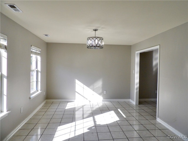 unfurnished dining area with a chandelier and light tile patterned floors