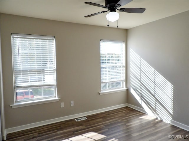 unfurnished room featuring dark hardwood / wood-style floors, plenty of natural light, and ceiling fan