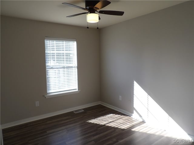 empty room featuring dark wood-type flooring and ceiling fan